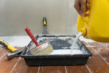 Bir inşaat işçisi tepsiye boya ya da inşaat karışımı döker. Evde inşaatçı ya da tamirci olarak çalış. Bir odayı bitiriyor ya da onarıyor. Tamirci daireyi tamir eder..