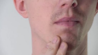 Genç bir adam banyoya köpük sürmeden ya da tıraş jeli sürmeden önce yüzünün derisini ve sakalını okşar. Yüz bakımı, sakal tıraşı, sakal, bıyık ve sakal. Tıraşsız adam.