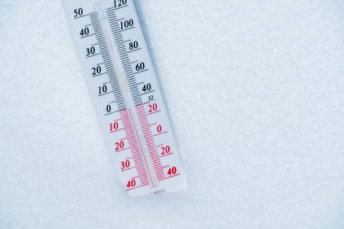 Termometre karın üzerinde yatar ve mavi gökyüzünde soğuk havada negatif bir sıcaklık gösterir. Düşük hava ve ortam sıcaklıklarına sahip meteorolojik koşullar. İklim değişikliği ve küresel ısınma