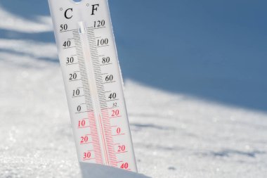 Termometre karın üzerinde yatar ve mavi gökyüzünde soğuk havada negatif bir sıcaklık gösterir. Düşük hava ve ortam sıcaklıklarına sahip meteorolojik koşullar. İklim değişikliği ve küresel ısınma