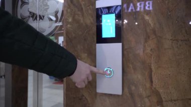 Eller panelin üstündeki asansör düğmesine basarak yukarı çıkıyor. Ara ve asansöre bin..