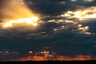 Güneşin ilahi ışığı. Güneşin bulutları ve ışınlarıyla dramatik akşam gökyüzü. Akşam gün batımında ya da sabah şafağında güneş ışığı. Mavi gökyüzünün hareketli panoramik görüntüsü.