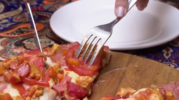 トマトとキノコが入ったフレッシュジューシーなチーズピザをナイフで切り プレートにフォークをかけます ピッツェリア カフェ レストラン 食堂や食堂でおいしい料理 交換テーブルの上のピザ — ストック動画