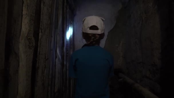 一个吓坏了的小女孩惊慌失措地沿着一座旧建筑的底层走着 闪烁着一盏灯 一个戏剧性的电影场景 一个孩子在地下室的半黑暗中 — 图库视频影像