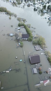 Büyük bir şehrin su altında evleri ve caddeleri olan insansız hava aracı görüntüleri. Şiddetli hava ve sağanak yağış kaynaklı kentsel sel, yerleşim alanları üzerinde doğal afet etkisi gösteriyor. İklim değişikliği