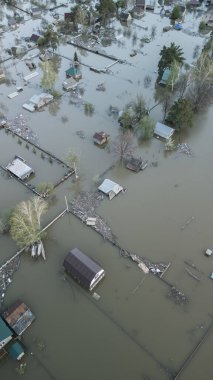 Büyük bir şehrin su altında evleri ve caddeleri olan insansız hava aracı görüntüleri. Şiddetli hava ve sağanak yağış kaynaklı kentsel sel, yerleşim alanları üzerinde doğal afet etkisi gösteriyor. İklim değişikliği