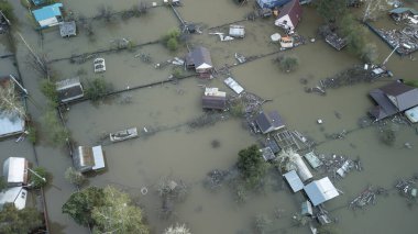 Büyük bir şehrin su altında evleri ve caddeleri olan insansız hava aracı görüntüleri. Şiddetli hava ve sağanak yağış kaynaklı kentsel sel, yerleşim alanları üzerinde doğal afet etkisi gösteriyor. İklim değişikliği