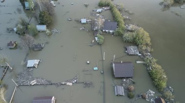 Büyük bir şehrin su altında evleri ve caddeleri olan insansız hava aracı görüntüleri. Şiddetli hava ve sağanak yağış kaynaklı kentsel sel, yerleşim alanları üzerinde doğal afet etkisi gösteriyor. İklim değişikliği