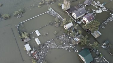Büyük bir şehrin su altında evleri ve caddeleri olan insansız hava aracı görüntüleri. Şiddetli hava ve sağanak yağış kaynaklı kentsel sel, yerleşim alanları üzerinde doğal afet etkisi gösteriyor. İklim değişikliği
