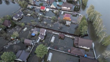 Büyük bir şehrin su altında evleri ve caddeleri olan insansız hava aracı görüntüleri. Şiddetli hava ve sağanak yağış kaynaklı kentsel sel, yerleşim alanları üzerinde doğal afet etkisi gösteriyor. İklim değişikliği