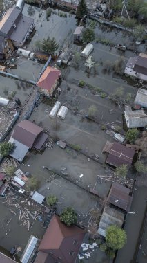 Büyük bir şehrin su altında evleri ve caddeleri olan insansız hava aracı görüntüleri. Şiddetli hava ve sağanak yağış kaynaklı kentsel sel, yerleşim alanları üzerinde doğal afet etkisi gösteriyor. İklim değişikliği
