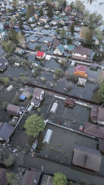 Büyük bir şehrin su altında evleri ve caddeleri olan insansız hava aracı görüntüleri. Şiddetli hava ve sağanak yağış kaynaklı kentsel sel, yerleşim alanları üzerinde doğal afet etkisi gösteriyor. İklim değişikliği