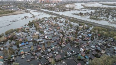 Büyük bir şehrin su altında evleri ve caddeleri olan insansız hava aracı görüntüleri. Şiddetli hava ve sağanak yağış kaynaklı kentsel sel, yerleşim alanları üzerinde doğal afet etkisi gösteriyor. İklim değişikliği