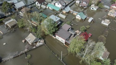 Büyük bir şehrin su altında evleri ve caddeleri olan insansız hava aracı görüntüleri. Şiddetli hava ve sağanak yağış kaynaklı kentsel sel, yerleşim alanları üzerinde doğal afet etkisi gösteriyor. İklim değişikliği