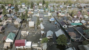 Büyük bir şehrin su altında evleri ve caddeleri olan insansız hava aracı görüntüleri. Şiddetli hava ve sağanak yağış kaynaklı kentsel sel, yerleşim alanları üzerinde doğal afet etkisi gösteriyor. İklim değişikliği