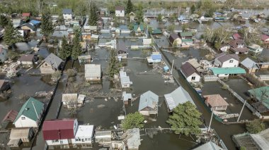 Büyük bir şehrin su altında evleri ve caddeleri olan insansız hava aracı görüntüleri. Şiddetli hava ve sağanak yağış kaynaklı kentsel sel, yerleşim alanları üzerinde doğal afet etkisi gösteriyor. İklim değişikliği