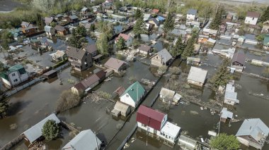 Büyük bir şehrin su altında evleri ve caddeleri olan insansız hava aracı görüntüleri. Şiddetli hava ve sağanak yağış kaynaklı kentsel sel, yerleşim alanları üzerinde doğal afet etkisi gösteriyor. İklim değişikliği