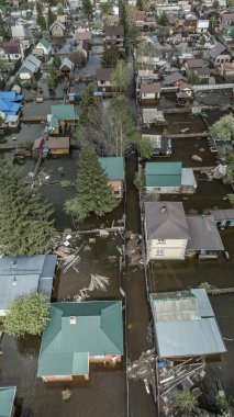 Büyük bir şehrin su altında evleri ve caddeleri olan insansız hava aracı görüntüleri. Şiddetli hava ve sağanak yağış kaynaklı kentsel sel, yerleşim alanları üzerinde doğal afet etkisi gösteriyor. İklim değişikliği