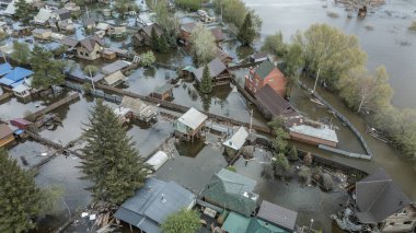 Büyük bir şehrin su altında evleri ve caddeleri olan insansız hava aracı görüntüleri. Şiddetli hava ve sağanak yağış kaynaklı kentsel sel, yerleşim alanları üzerinde doğal afet etkisi gösteriyor. İklim değişikliği