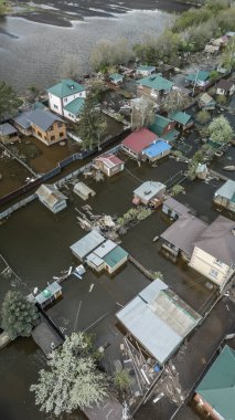 Büyük bir şehrin su altında evleri ve caddeleri olan insansız hava aracı görüntüleri. Şiddetli hava ve sağanak yağış kaynaklı kentsel sel, yerleşim alanları üzerinde doğal afet etkisi gösteriyor. İklim değişikliği