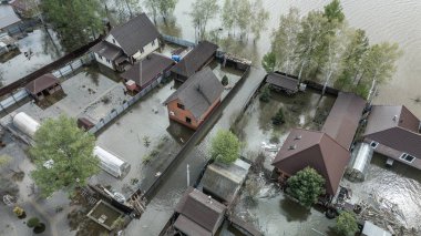 Büyük bir şehrin su altında evleri ve caddeleri olan insansız hava aracı görüntüleri. Şiddetli hava ve sağanak yağış kaynaklı kentsel sel, yerleşim alanları üzerinde doğal afet etkisi gösteriyor. İklim değişikliği