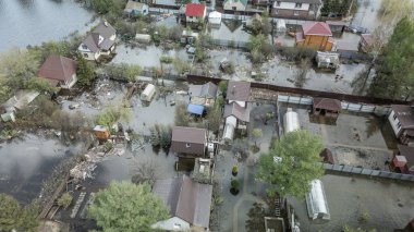 Büyük bir şehrin su altında evleri ve caddeleri olan insansız hava aracı görüntüleri. Şiddetli hava ve sağanak yağış kaynaklı kentsel sel, yerleşim alanları üzerinde doğal afet etkisi gösteriyor. İklim değişikliği