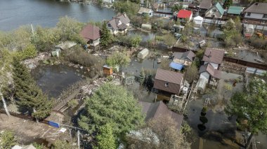 Büyük bir şehrin su altında evleri ve caddeleri olan insansız hava aracı görüntüleri. Şiddetli hava ve sağanak yağış kaynaklı kentsel sel, yerleşim alanları üzerinde doğal afet etkisi gösteriyor. İklim değişikliği