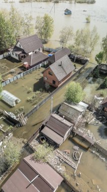 Büyük bir şehrin su altında evleri ve caddeleri olan insansız hava aracı görüntüleri. Şiddetli hava ve sağanak yağış kaynaklı kentsel sel, yerleşim alanları üzerinde doğal afet etkisi gösteriyor. İklim değişikliği