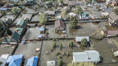 Büyük bir şehrin su altında evleri ve caddeleri olan insansız hava aracı görüntüleri. Şiddetli hava ve sağanak yağış kaynaklı kentsel sel, yerleşim alanları üzerinde doğal afet etkisi gösteriyor. İklim değişikliği