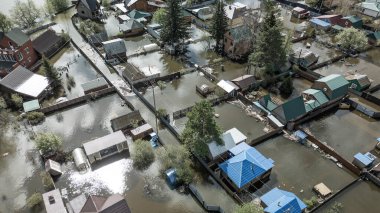 Büyük bir şehrin su altında evleri ve caddeleri olan insansız hava aracı görüntüleri. Şiddetli hava ve sağanak yağış kaynaklı kentsel sel, yerleşim alanları üzerinde doğal afet etkisi gösteriyor. İklim değişikliği