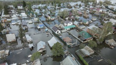 Büyük bir şehrin su altında evleri ve caddeleri olan insansız hava aracı görüntüleri. Şiddetli hava ve sağanak yağış kaynaklı kentsel sel, yerleşim alanları üzerinde doğal afet etkisi gösteriyor. İklim değişikliği