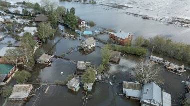 Büyük bir şehrin su altında evleri ve caddeleri olan insansız hava aracı görüntüleri. Şiddetli hava ve sağanak yağış kaynaklı kentsel sel, yerleşim alanları üzerinde doğal afet etkisi gösteriyor. İklim değişikliği