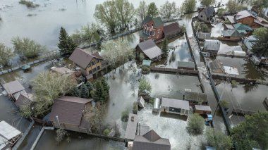 Büyük bir şehrin su altında evleri ve caddeleri olan insansız hava aracı görüntüleri. Şiddetli hava ve sağanak yağış kaynaklı kentsel sel, yerleşim alanları üzerinde doğal afet etkisi gösteriyor. İklim değişikliği