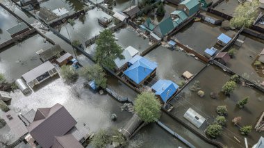 Büyük bir şehrin su altında evleri ve caddeleri olan insansız hava aracı görüntüleri. Şiddetli hava ve sağanak yağış kaynaklı kentsel sel, yerleşim alanları üzerinde doğal afet etkisi gösteriyor. İklim değişikliği
