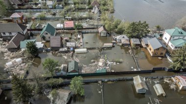 Büyük bir şehrin su altında evleri ve caddeleri olan insansız hava aracı görüntüleri. Şiddetli hava ve sağanak yağış kaynaklı kentsel sel, yerleşim alanları üzerinde doğal afet etkisi gösteriyor. İklim değişikliği