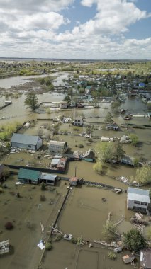 Büyük ölçekli bir sel felaketi. Tamamen sular altında kalmış evler, sular altında kalmış yollar ve taşmış su yolları. Görüntüler şiddetli yağış ve yükselen su seviyelerinin yerleşim alanları, altyapı ve doğal çevre üzerindeki dramatik etkisini gösteriyor..