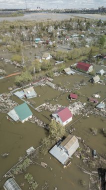 Büyük ölçekli bir sel felaketi. Tamamen sular altında kalmış evler, sular altında kalmış yollar ve taşmış su yolları. Görüntüler şiddetli yağış ve yükselen su seviyelerinin yerleşim alanları, altyapı ve doğal çevre üzerindeki dramatik etkisini gösteriyor..