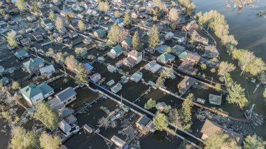 Büyük ölçekli bir sel felaketi. Tamamen sular altında kalmış evler, sular altında kalmış yollar ve taşmış su yolları. Görüntüler şiddetli yağış ve yükselen su seviyelerinin yerleşim alanları, altyapı ve doğal çevre üzerindeki dramatik etkisini gösteriyor..