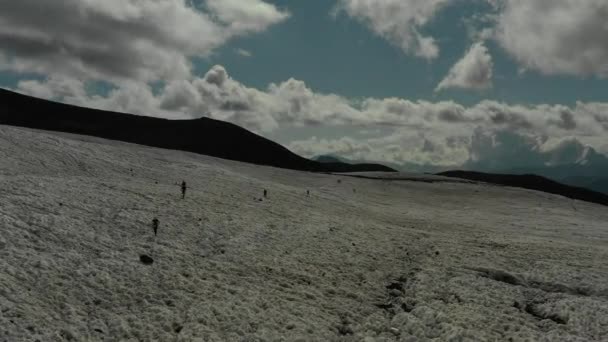 Lot lotniczy nad grupą osób poruszających się na lodowcu w regionie Elbrus. — Wideo stockowe