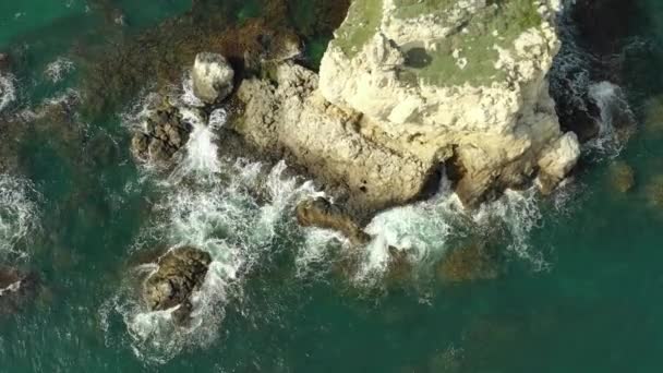 Vista aérea superior das ondas do oceano respingo contra fundo rochas. — Vídeo de Stock