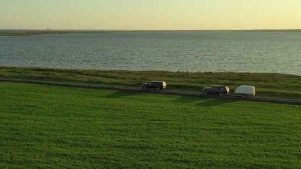 Samochody jadące po ziemi drogi witn trawy. — Wideo stockowe