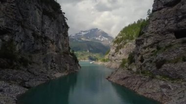 İnsansız hava aracı göl kenarındaki kayaların arasından ilerliyor.