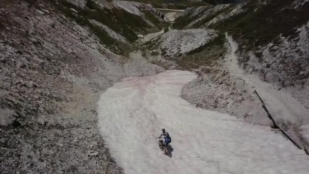 Tiro aéreo acima motociclista de montanha no desfiladeiro de neve — Vídeo de Stock