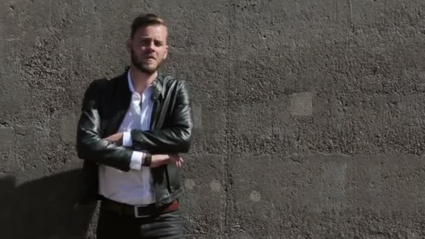 Όμορφος άντρας κλίνει ενάντια σε έναν τοίχο — Αρχείο Βίντεο