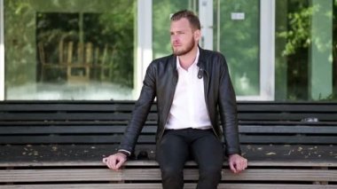 Yalnız adam açık havada bankta oturuyor