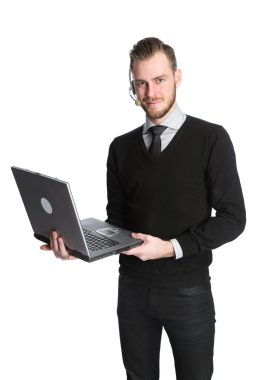 Çekici işadamı bir kulaklık giyen ve bir dizüstü bilgisayar tutan teknoloji ile çalışma