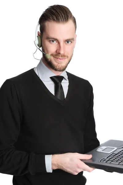 Attraktiver Geschäftsmann, der mit Technologie arbeitet, ein Headset trägt und einen Laptop in der Hand hält — Stockfoto