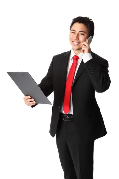 Smiling businessman with phone and clipboard — Stock Photo, Image