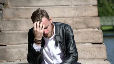 Dalgın çekici adam oturuyor aşağı dışarıda