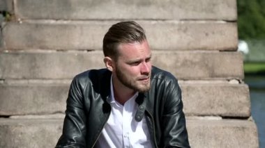 Dalgın çekici adam oturuyor aşağı dışarıda